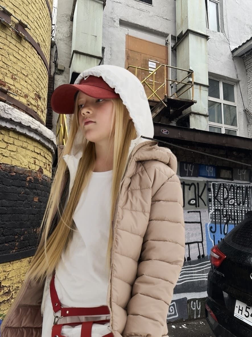 Девушка в многослойном образе из новой коллекции Brinco на фоне осенней индустриальной локации.
